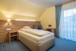 una camera d'albergo con letto e finestra di Hotel-Pension Falkensteiner a Sankt Gilgen