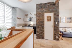 een keuken en een woonkamer met een bakstenen muur bij Tassigny - Charmant appartement/ terrasse - Port in Vannes