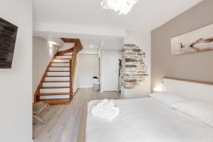 een slaapkamer met een wit bed en een trap bij Tassigny - Charmant appartement/ terrasse - Port in Vannes