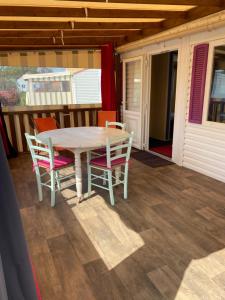 a table and chairs on the porch of a house at Mobil Home 5 personnes - Camping *** Les Ollivaud- in La Baule