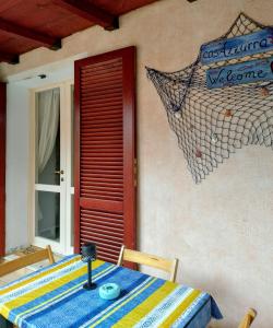 una mesa con un mantel azul y amarillo y una puerta roja en Casa Azzurra, en Capitana