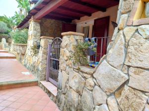 una pared de piedra frente a una casa con una puerta en Casa Azzurra, en Capitana