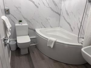 a bathroom with a tub and a toilet and a sink at Aston Court Hotel in Derby