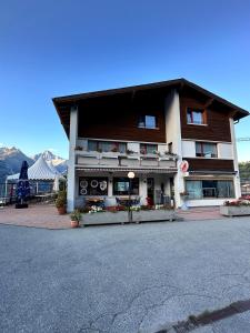 a building on the side of a street with mountains in the background at Haus Augstbord BNB Zimmer in Unterbäch