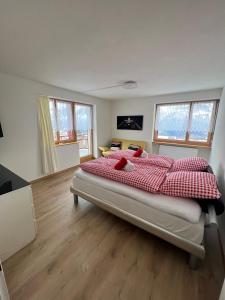 sypialnia z dużym łóżkiem z białymi i czerwonymi poduszkami w obiekcie Haus Augstbord BNB Zimmer w mieście Unterbäch