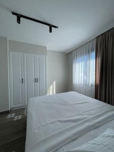een slaapkamer met een wit bed en een raam bij Zehra Suites Boutique Apartment#6, 300 meters from the sea in Marmaris