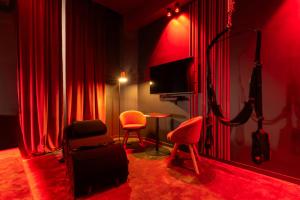 a red room with red curtains and chairs and a television at Évasion intime : Love Room de luxe à Cannes in Cannes