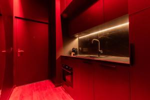 a red kitchen with a sink and red cabinets at Évasion intime : Love Room de luxe à Cannes in Cannes