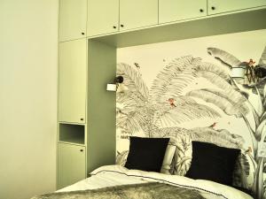 a bedroom with a bed with a mural of feathers at Le Bijou in Neuilly-sur-Seine