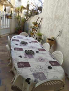 a table with a floral table cloth on a patio at La Maison du Vent du Soleil - située au cœur de la Camargue in Saintes-Maries-de-la-Mer
