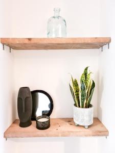 un estante con una botella de cristal y una planta en 4-Bedroom home - Perfect for those working in Bridgend - By Tailored Accommodation, en Bridgend