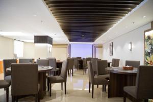 uma sala de jantar com mesas e cadeiras e um tecto em Sun & Moon Bacca Hotel em Meca