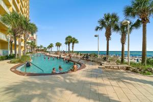 a group of people in a swimming pool next to the beach at Calypso Beach Resort in Panama City Beach