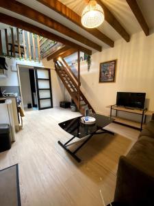 ein Wohnzimmer mit einem Sofa und einem Tisch in der Unterkunft Charmant et paisible duplex à gare Rennes in Rennes