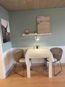 Seeluft direkt am Wasser في رايشناو: طاولة بيضاء وكراسي في غرفة