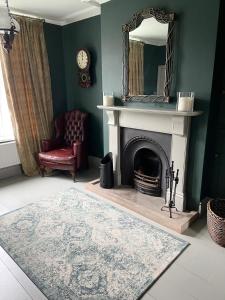 a living room with a fireplace and a mirror at Sherwood House in Matlock