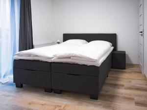 a bedroom with a bed with white sheets on it at VacationClub - Siedem Wysp Apartament 31 in Sianozety