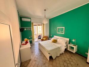 Dormitorio verde con cama y pared verde en Reginella Guest House, en Salerno