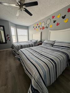 a bedroom with two beds and a ceiling fan at FMH Property Management in Orlando