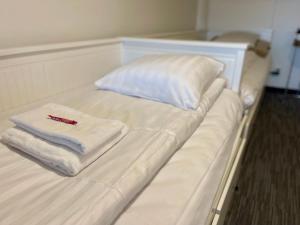 uma cama branca com toalhas e um termómetro em Vid Gekås Ullared Boende B&B em Ullared
