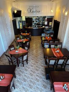 un restaurante con mesas y sillas de madera y un bar en Hotel "XAVIER", en Lubycza Królewska