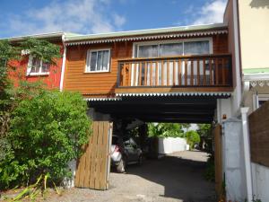 una casa con un ponte con una macchina sotto di Chalet Canne à Sucre a Saint-André