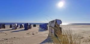 a beach with many trash cans in the sand at Ferienwohnung Wellenreiter 200 m zum Strand Fewo strandnah mit Balkon Parkplatz Wlan in Karlshagen +25 photos