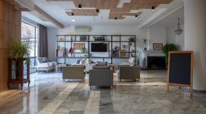 sala de estar con sofá, sillas y chimenea en Alliance Hotel, en Tiflis