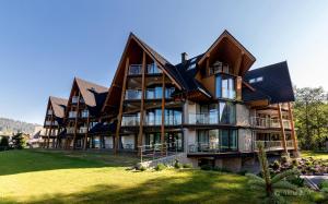 ein großes Haus auf einem Hügel mit grünem Rasen in der Unterkunft Harenda Residence in Zakopane
