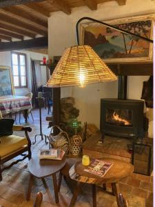 a living room with a fireplace and a lamp at La Toumet in Malabat