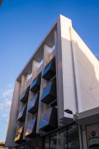 a building with blue windows on the side of it at Raam Luxury Suites in Larnaca