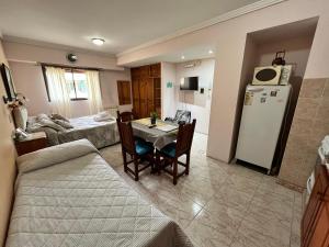 a kitchen and living room with a table and a refrigerator at Complejo El Puente in Puerto Madryn