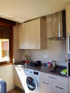 a kitchen with a washing machine and a sink at Estudio con vistas al mar in Moaña