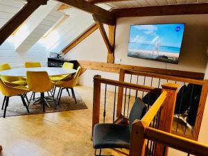 a dining room with a table and a tv on a wall at E & A LOSSI 21/23 in Tartu