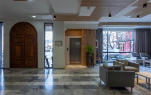 an office lobby with a wooden door and couches at Alliance Hotel in Tbilisi City