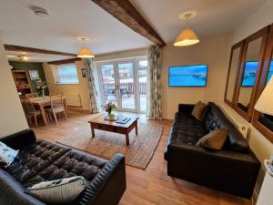 een woonkamer met een bank en een tafel bij Cowman's Cottage in Leighton Buzzard