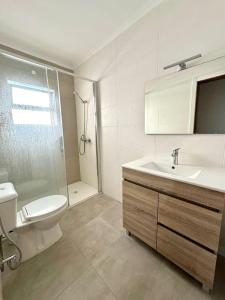 a bathroom with a sink and a toilet and a shower at Fabuloso T3 Praia dos Pescadores in Albufeira