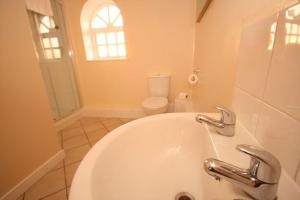 a bathroom with a white tub and a toilet at Grooms Cottage in Leighton Buzzard +15 photos