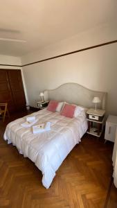 a large white bed with two towels and two tables at Hotel con Hermosa Vista al Mar MDQ in Mar del Plata