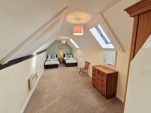 a attic bedroom with two beds and a desk at The Homestead in Leighton Buzzard