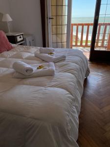 two beds in a room with towels on them at Hotel con Hermosa Vista al Mar MDQ in Mar del Plata