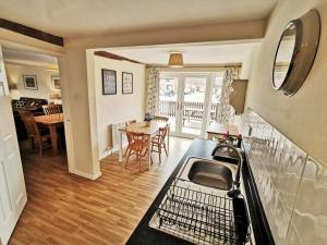 a kitchen with a sink and a table with chairs at The Old Stables in Leighton Buzzard