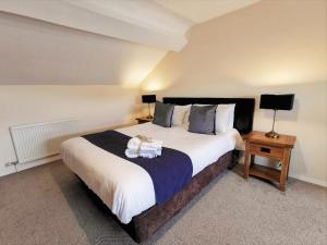 um quarto com uma cama grande e duas mesas de cabeceira em The Old Stables em Leighton Buzzard