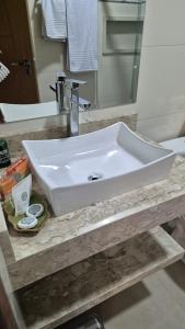 a white sink on a counter in a bathroom at Pousada Recanto Família Suíte com Hidro in Paraty +2 photos