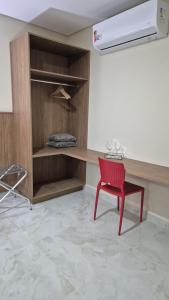 a red chair in a room with a desk at Pousada Recanto Família Suíte com Hidro in Paraty