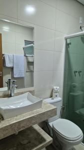 a bathroom with a sink and a toilet and a shower at Pousada Recanto Família Suíte com Hidro in Paraty