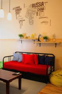 a red couch sitting in a room with a table at LEM Family Apartment in Budapest