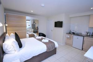 um quarto de hotel com uma cama grande e uma cozinha em The Egg Room em Ivinghoe
