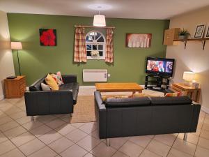 een woonkamer met twee banken en een tv bij Lime Kiln in Leighton Buzzard
