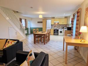 ein Wohnzimmer und eine Küche mit einem Sofa und einem Tisch in der Unterkunft Lime Kiln in Leighton Buzzard